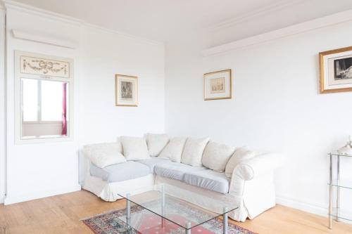 - un salon blanc avec un canapé blanc et une table en verre dans l'établissement Apartment for 3 overlooking the Eiffel Tower, à Boulogne-Billancourt