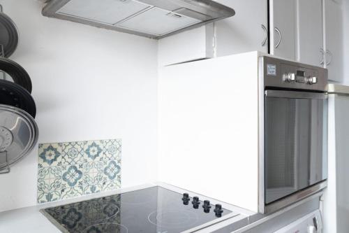 une cuisine avec un micro-ondes et une cuisinière four supérieur dans l'établissement Apartment for 3 overlooking the Eiffel Tower, à Boulogne-Billancourt