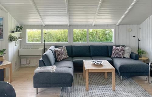 a living room with a blue couch and a table at Gorgeous Home In Sjølund With Sauna in Sjølund