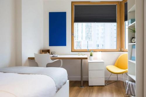 a bedroom with a bed and a desk and a window at Chapter Aldgate London in London
