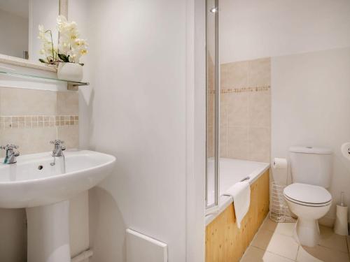 a white bathroom with a sink and a toilet at Lisle Combe Cottage in Ventnor