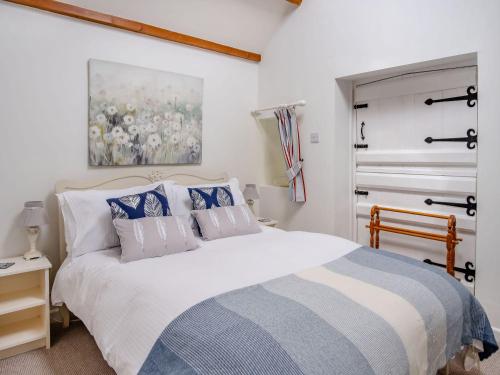 a bedroom with a large white bed and a window at Lisle Combe Cottage in Ventnor