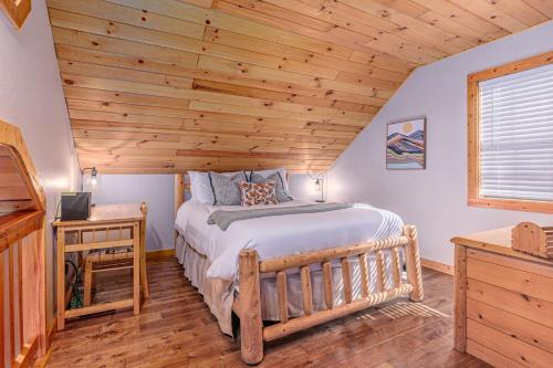 a bedroom with a bed and a wooden ceiling at Whispering Pines Cabin in Whittier