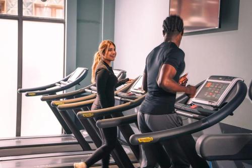 a man and woman running on treadles in a gym at Chapter Spitalfields in London in London