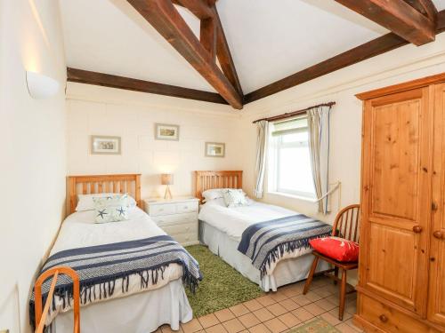Un dormitorio con dos camas y una ventana. en Swallows, en Ventnor