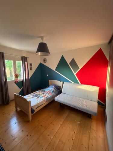 une chambre avec un lit et un canapé dans une pièce dans l'établissement Villa familiale avec piscine chauffée, à La Lande-de-Fronsac