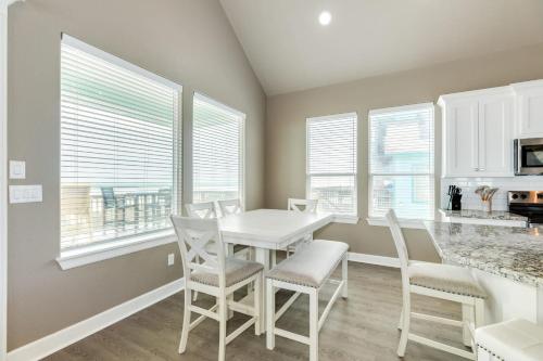 a dining room with a table and chairs and windows at Sea Holly - Beachfront - Pet & Family Friendly in Freeport