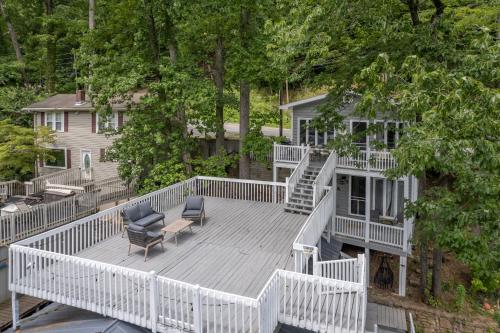 a large deck with two chairs and a table at Waters Edge Hideaway Lakefront Pet Friendly in Lake Lure
