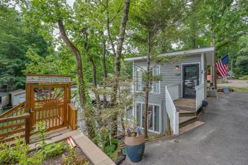 a tiny house with a porch and an american flag at Waters Edge Hideaway Lakefront Pet Friendly in Lake Lure