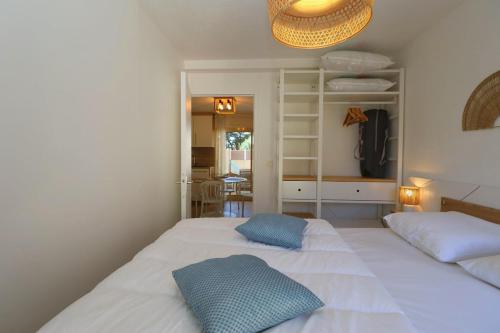 une chambre avec deux lits avec des oreillers bleus dessus dans l'établissement Le Belouga By Tranquil at Home, à Pornichet