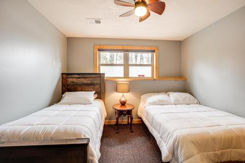 イーグル・リバーにあるBoat Dock and Furnished Deck Northwoods Lake Houseのベッド2台と窓のある寝室