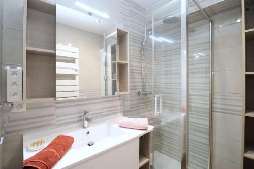 une salle de bain avec un lavabo et une douche dans l'établissement Le Belouga By Tranquil at Home, à Pornichet