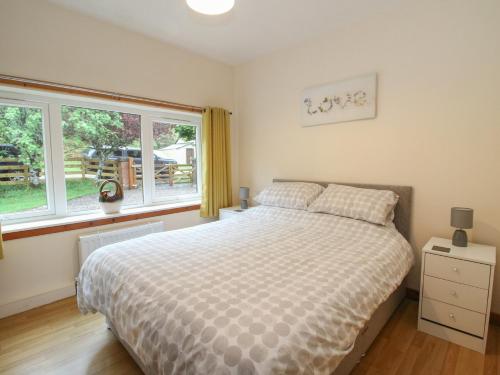 una camera da letto con un letto e una grande finestra di Cooinda Cottage a Morar