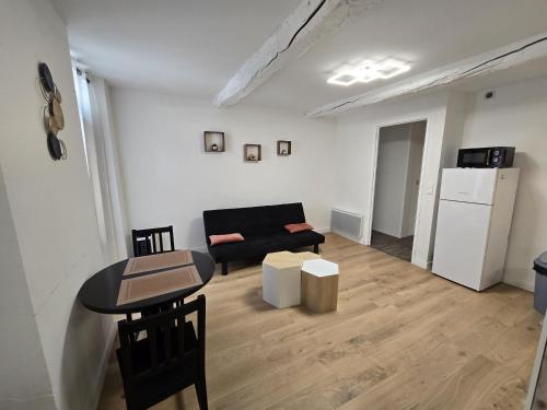 un salon avec un canapé noir et une table dans l'établissement Très belle appartement, à Digne-Les-Bains