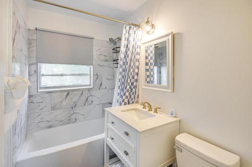 a bathroom with a sink and a toilet and a tub at 4 Mi to Daytona Boardwalk and Beaches Cute Cottage in Holly Hill