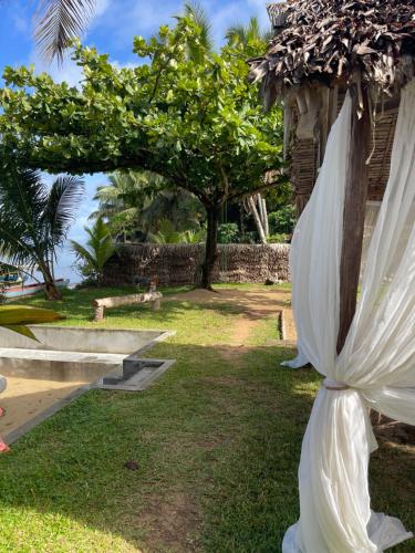 a white umbrella hanging from the side of a building at La Spiaggia, tropical villa with private beach in Sainte Marie
