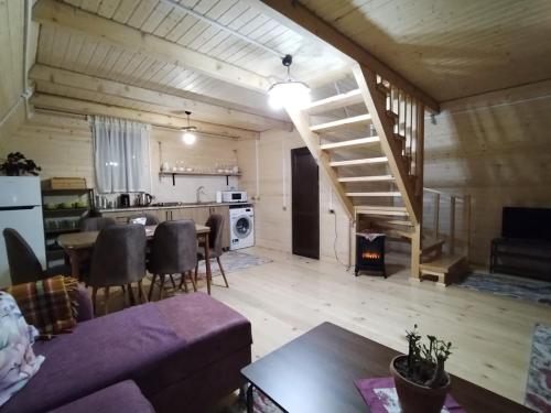a living room and kitchen with a staircase in a house at Guesthouse Venera in Mestia