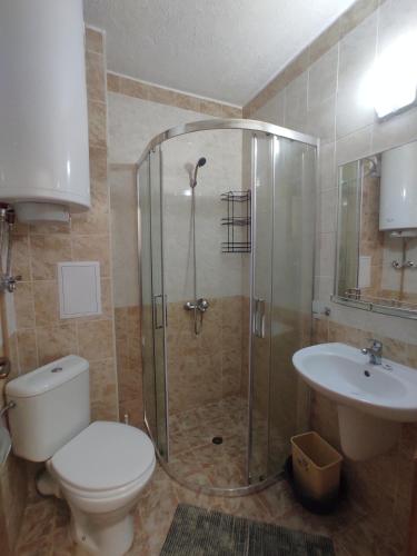 ein Badezimmer mit Dusche, Toilette und Waschbecken in der Unterkunft Double Cherry Apartment in Sonnenstrand