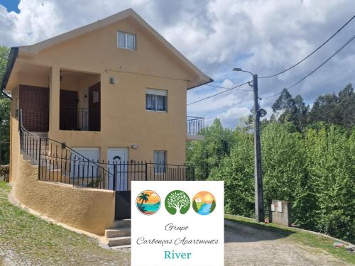 a house with a sign in front of it at Carbonças River Apartments in Ribeiros