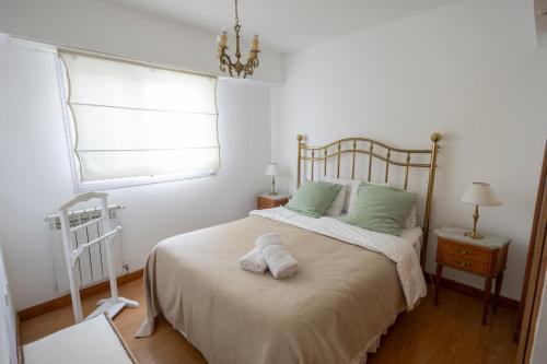 a bedroom with a bed with green pillows and a window at Ayres de Bolívar in San Carlos de Bolívar