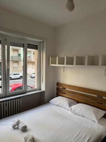 a bedroom with a bed and a large window at Gorizia Living in Turin