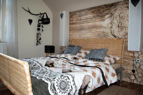 a bedroom with a bed with a large wooden headboard at Apartmany Villa Magnolie in Lipova Lazne