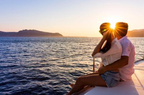 a man and a woman sitting on a boat in the water at White Cocoon Exclusive villas in Naxos Chora