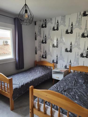 - une chambre avec 2 lits et un mur avec des châteaux dans l'établissement Appartement 3 pièces proche de la mer et centre avec parking privatif, à Valras-Plage
