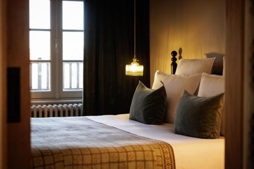 a bedroom with a bed with pillows and a window at Domaine de Locguénolé & Spa - Relais & Chateaux in Kervignac