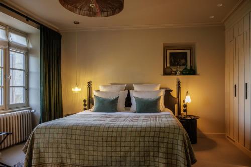 a bedroom with a bed with green and white pillows at Domaine de Locguénolé & Spa - Relais & Chateaux in Kervignac
