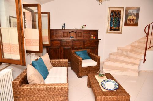 a living room with wicker chairs and a table at Da Minnia in Orgosolo