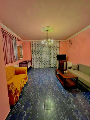 a living room with two couches and a tv at malina in Perlopsimades