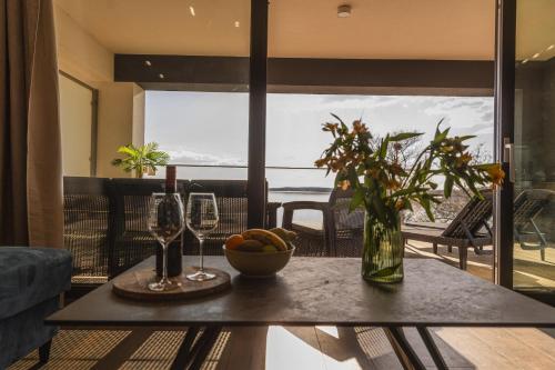 a table with a bowl of fruit and wine glasses at Apartamenty Boszkowo Horizon Sunset in Boszkowo