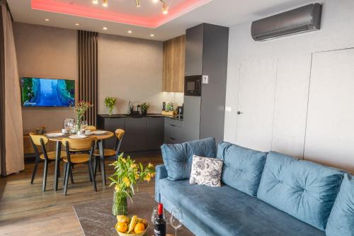 a living room with a blue couch and a table at Apartamenty Boszkowo Horizon Sunset in Boszkowo