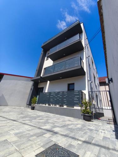 a large white building with a black fence at ROA Residence - premium apartments in Ploieşti