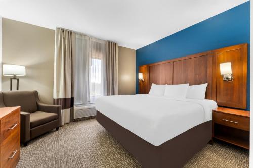 a hotel room with a large bed and a chair at Comfort Inn & Suites Augusta West Near Fort Eisenhower in Augusta