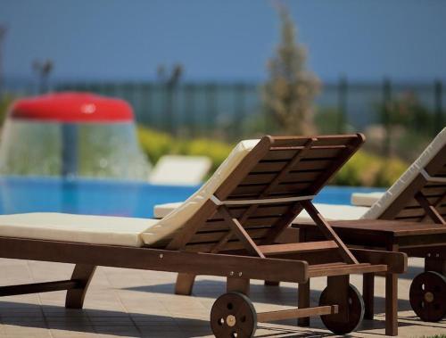 two lounge chairs sitting next to a swimming pool at Atia Resort in Chernomorets