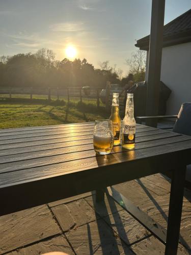 two bottles of beer sitting on a picnic table at Littleton Farm Barns in Saham Toney