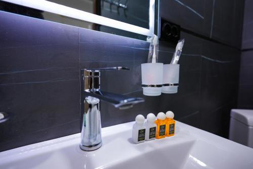 a bathroom sink with a faucet and a mirror at Chehran Hotel in Samarkand
