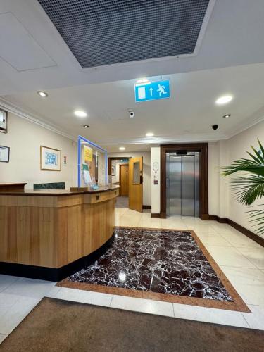 an office lobby with a reception desk and a marble floor at 2 Bedroom Apartment with security 24 hours in London