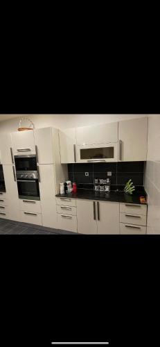 a kitchen with white cabinets and a black counter top at Villa Dar Lefrah in Tipaza