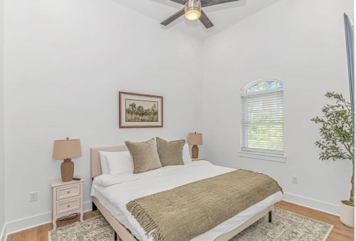 une chambre blanche avec un lit et un ventilateur de plafond dans l'établissement Beachside 5BR 5BTH Bungalow, 1 Block from Ocean, à Myrtle Beach