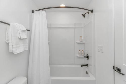 La salle de bains blanche est pourvue d'une douche et de toilettes blanches. dans l'établissement Beachside 5BR 5BTH Bungalow, 1 Block from Ocean, à Myrtle Beach