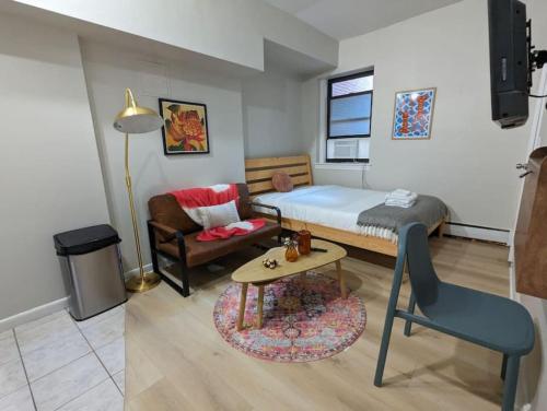 a bedroom with a bed and a table and a chair at Tranquil South End Studio in Boston