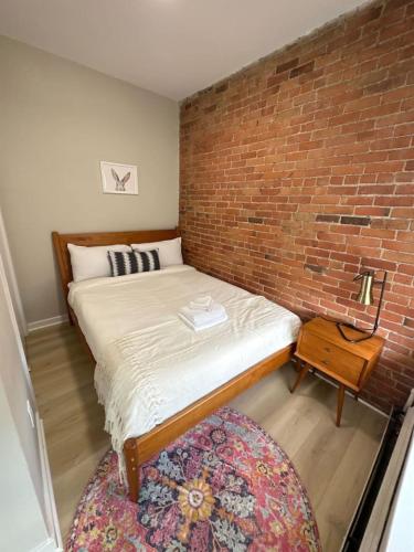 a bedroom with a brick wall and a bed at Bright and Cozy Studio Apartment in Boston