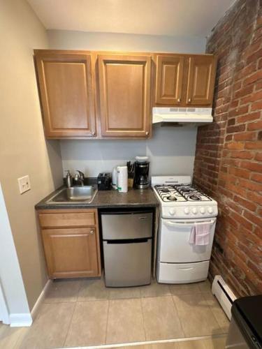 a small kitchen with a stove and a sink at Cozy Central South End Studio in Boston