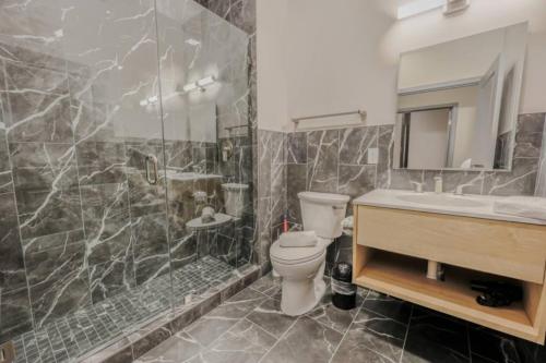 Un baño con inodoro, lavabo y ducha. en Chic Modern 2 bed Apartment with Exposed Brick, en Boston