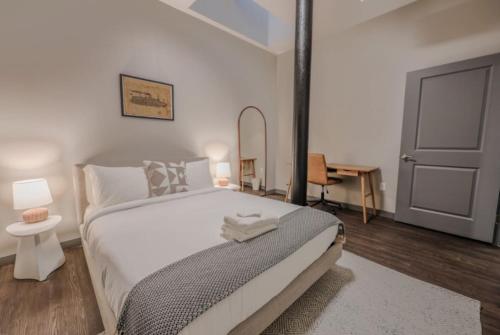 Un dormitorio blanco con una cama grande y un escritorio. en Chic Modern 2 bed Apartment with Exposed Brick, en Boston