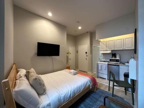 a small bedroom with a bed and a kitchen at Airy Studio South End in Boston