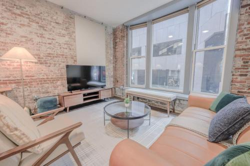 a living room with a brick wall and a tv at Downton Boston Luxurious 2 Bed in Boston
